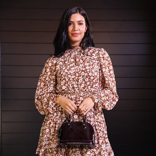 Woman wearing floral dress, holding handbag