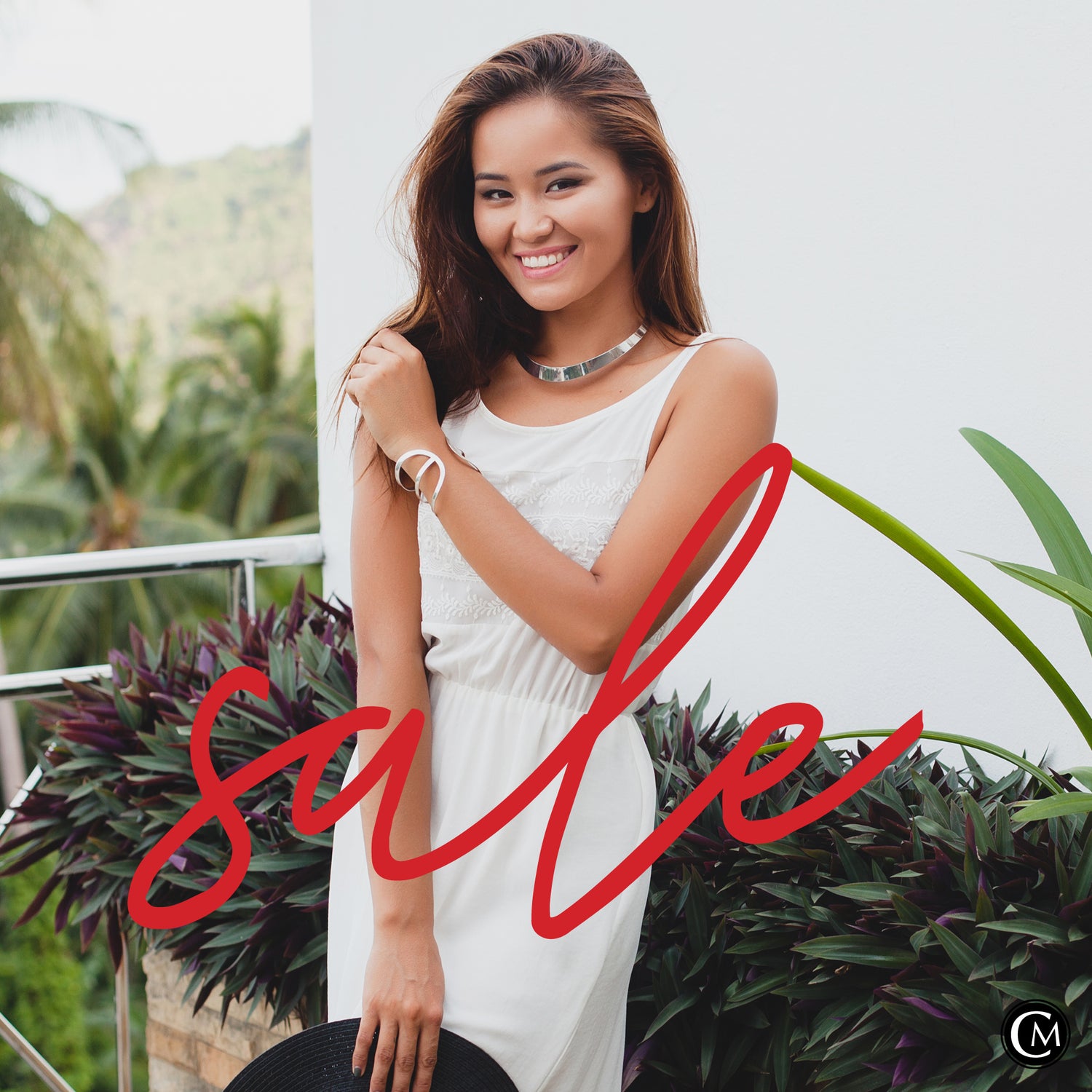 Woman in a white dress standing outdoors with plants and 'sale' text overlay